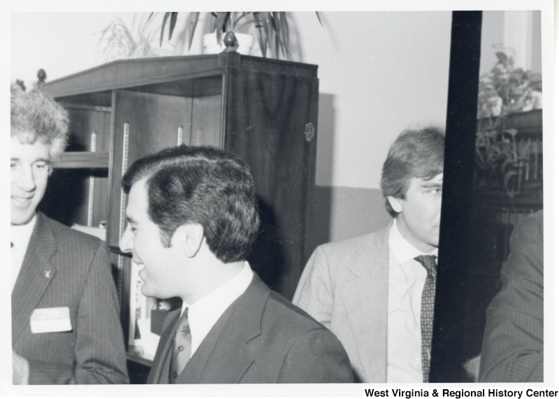 Congressman Nick Rahall speaking to a unidentified man. There is another unidentified man behind him.